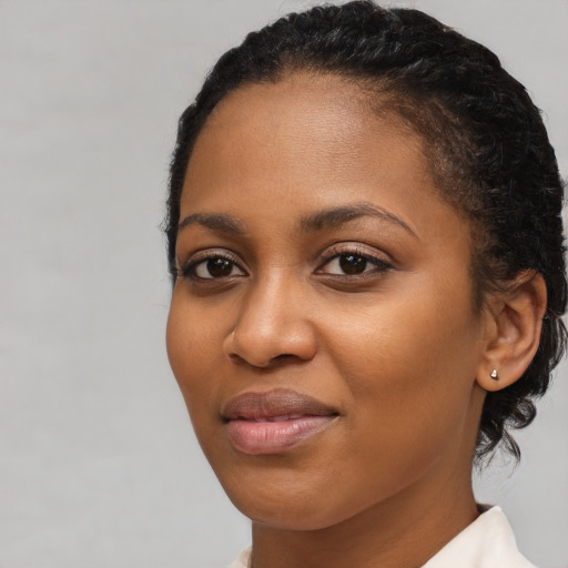 Joyful black young-adult female with short  brown hair and brown eyes