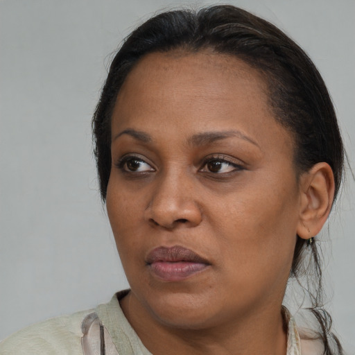 Joyful black young-adult female with medium  brown hair and brown eyes