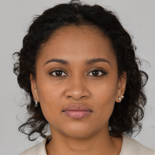 Joyful black young-adult female with medium  brown hair and brown eyes
