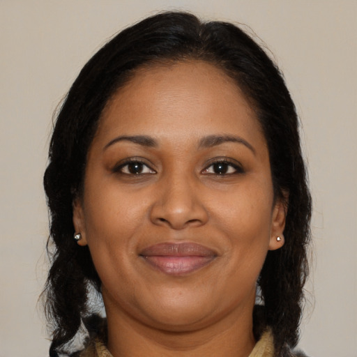 Joyful black adult female with long  brown hair and brown eyes