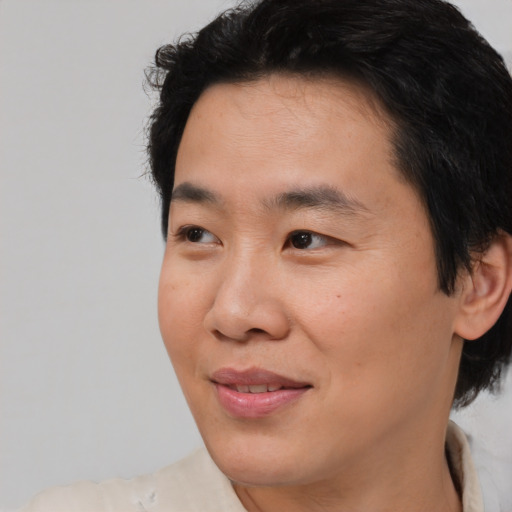 Joyful asian young-adult male with short  brown hair and brown eyes