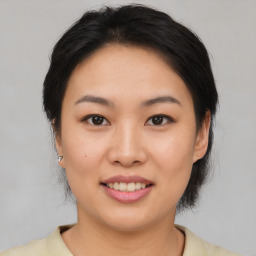 Joyful asian young-adult female with medium  brown hair and brown eyes