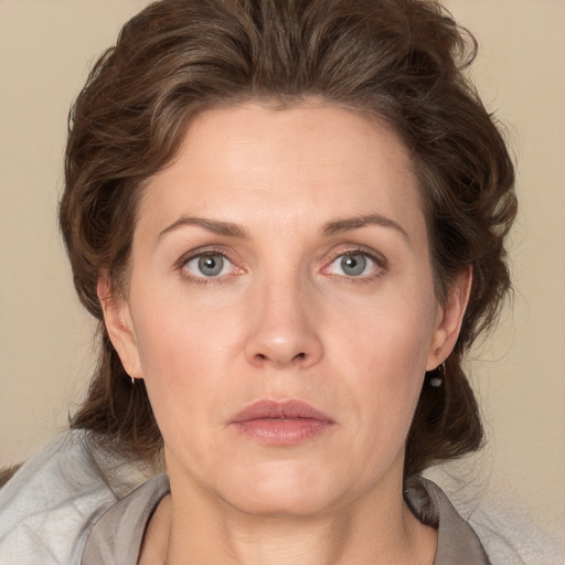 Joyful white adult female with medium  brown hair and grey eyes