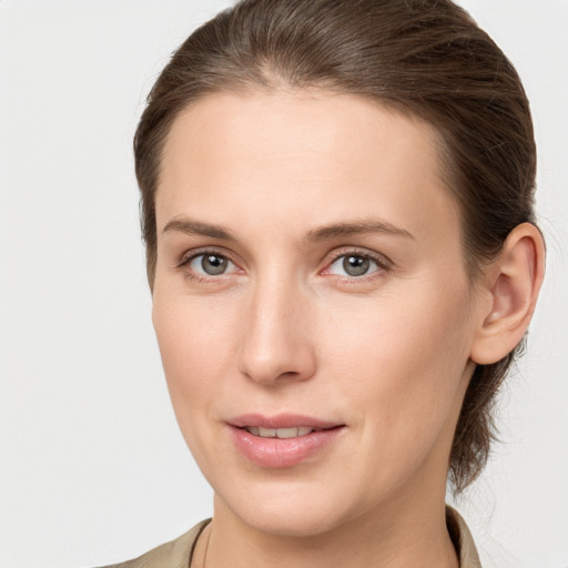 Joyful white young-adult female with medium  brown hair and grey eyes