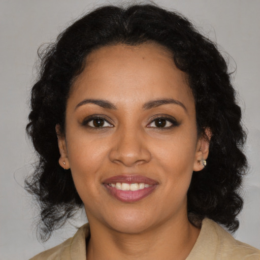 Joyful black young-adult female with medium  brown hair and brown eyes