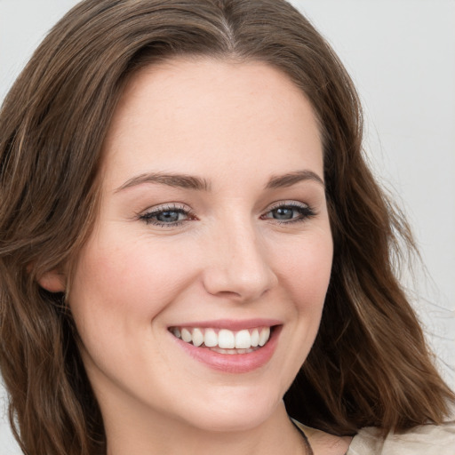 Joyful white young-adult female with long  brown hair and blue eyes