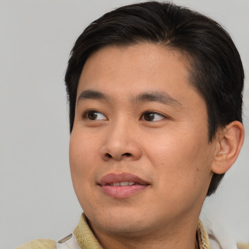 Joyful asian young-adult male with short  brown hair and brown eyes
