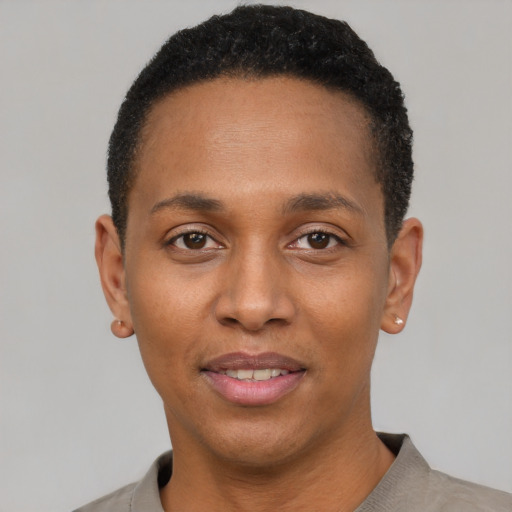 Joyful black young-adult female with short  black hair and brown eyes
