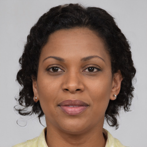 Joyful black adult female with medium  brown hair and brown eyes
