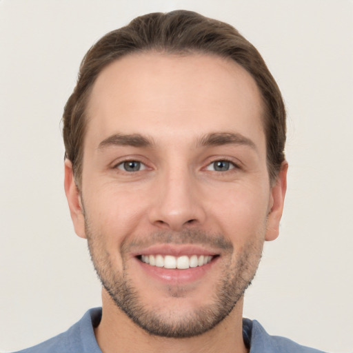 Joyful white young-adult male with short  brown hair and grey eyes