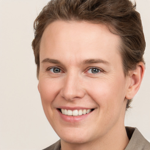 Joyful white young-adult female with short  brown hair and grey eyes