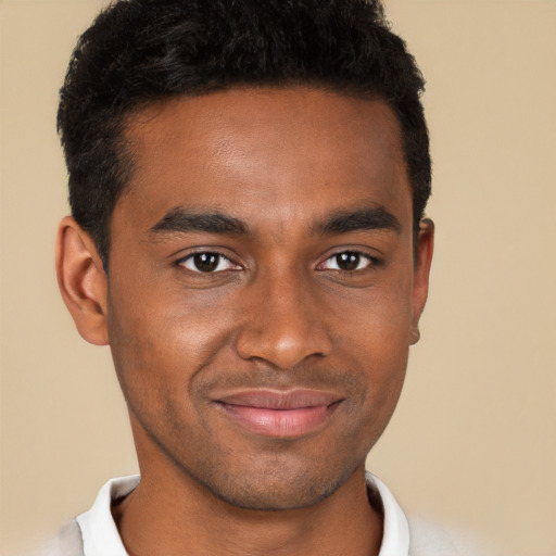 Joyful black young-adult male with short  brown hair and brown eyes