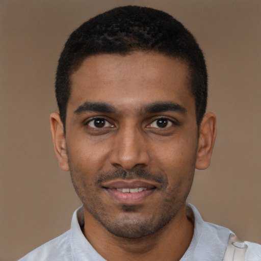 Joyful black young-adult male with short  black hair and brown eyes