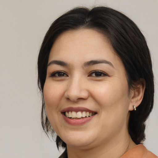 Joyful asian adult female with medium  brown hair and brown eyes