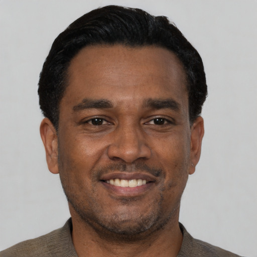 Joyful latino adult male with short  black hair and brown eyes