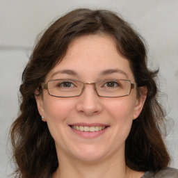 Joyful white adult female with medium  brown hair and green eyes