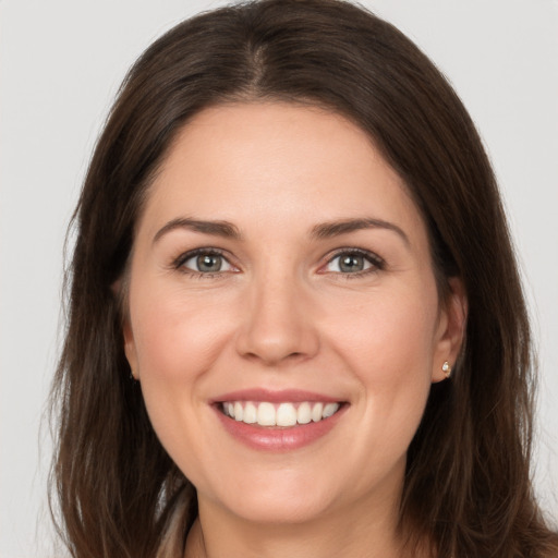 Joyful white young-adult female with long  brown hair and brown eyes