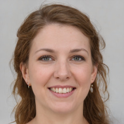 Joyful white young-adult female with medium  brown hair and green eyes