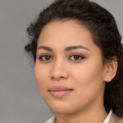 Joyful latino young-adult female with long  brown hair and brown eyes