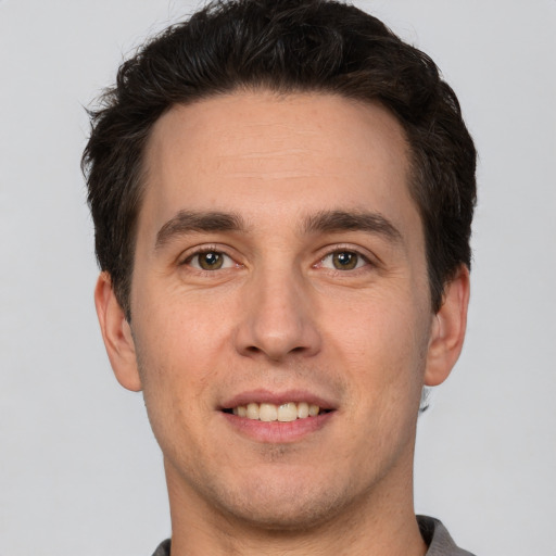 Joyful white young-adult male with short  brown hair and brown eyes