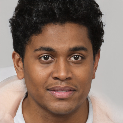 Joyful black young-adult male with short  brown hair and brown eyes