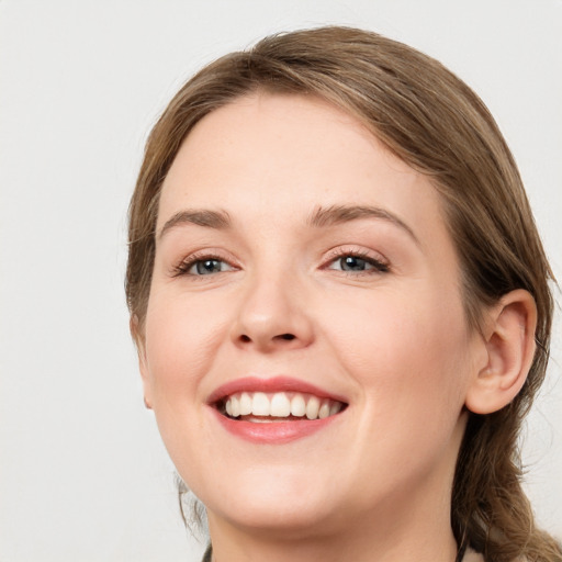 Joyful white young-adult female with medium  brown hair and grey eyes