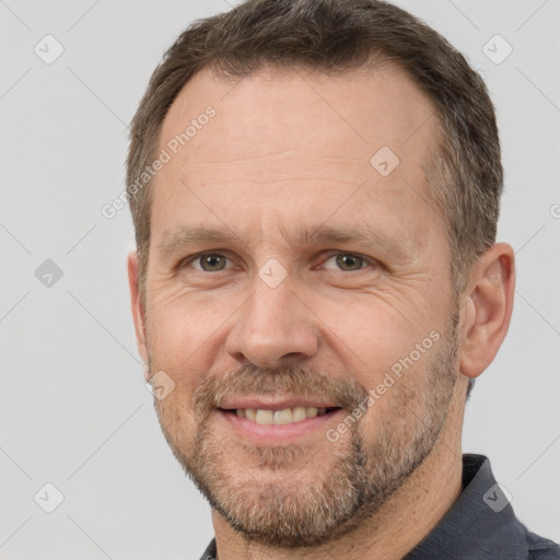 Joyful white adult male with short  brown hair and brown eyes