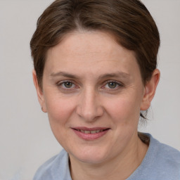 Joyful white young-adult female with short  brown hair and grey eyes