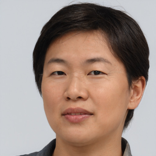 Joyful asian young-adult female with short  brown hair and brown eyes