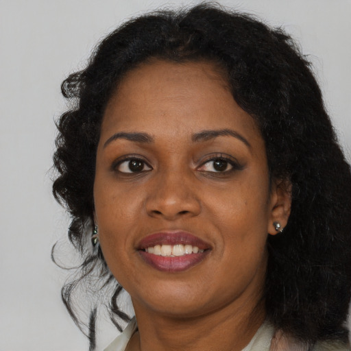 Joyful black adult female with long  brown hair and brown eyes