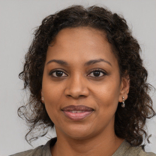 Joyful black young-adult female with medium  brown hair and brown eyes