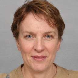 Joyful white adult female with short  brown hair and blue eyes