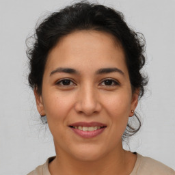 Joyful latino young-adult female with medium  brown hair and brown eyes