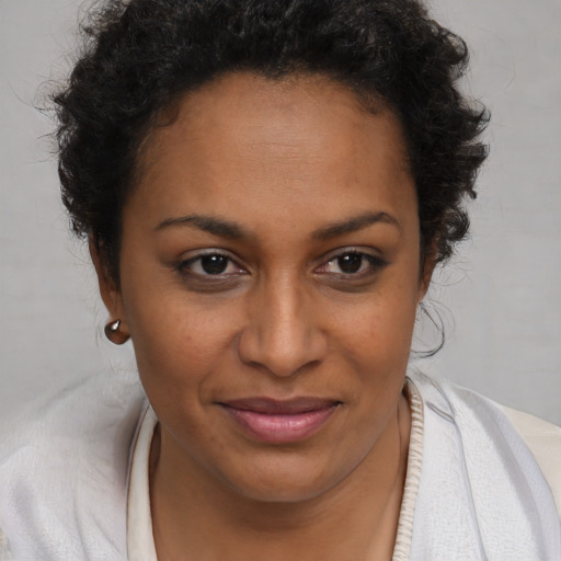 Joyful black young-adult female with short  brown hair and brown eyes