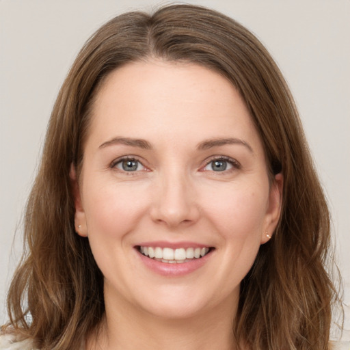 Joyful white young-adult female with long  brown hair and grey eyes