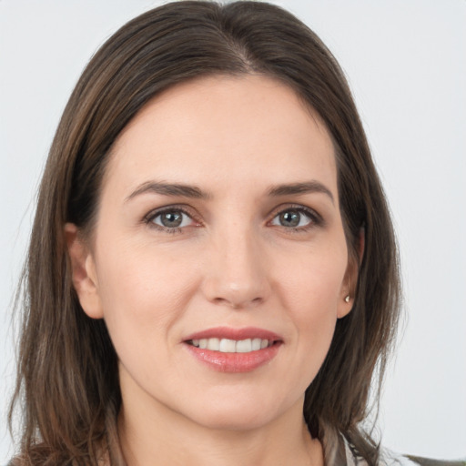 Joyful white young-adult female with long  brown hair and grey eyes