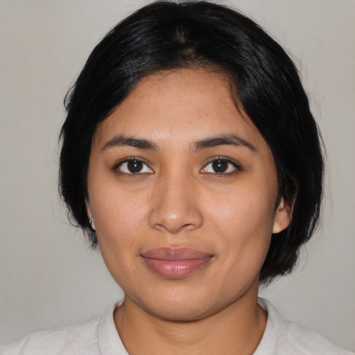 Joyful latino young-adult female with medium  black hair and brown eyes