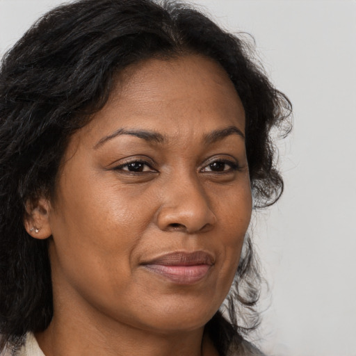 Joyful black adult female with long  brown hair and brown eyes