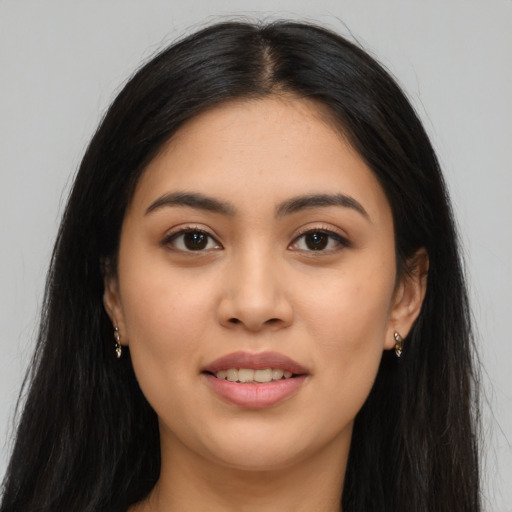 Joyful latino young-adult female with long  black hair and brown eyes