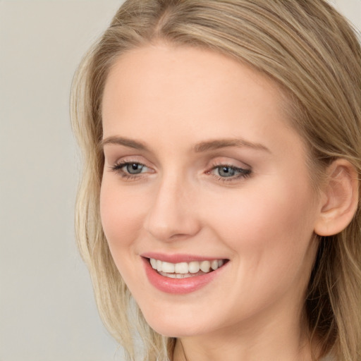 Joyful white young-adult female with long  brown hair and blue eyes