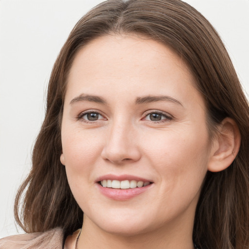 Joyful white young-adult female with long  brown hair and grey eyes