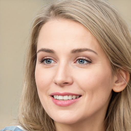 Joyful white young-adult female with long  brown hair and blue eyes