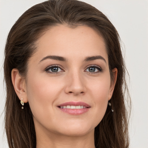 Joyful white young-adult female with long  brown hair and grey eyes