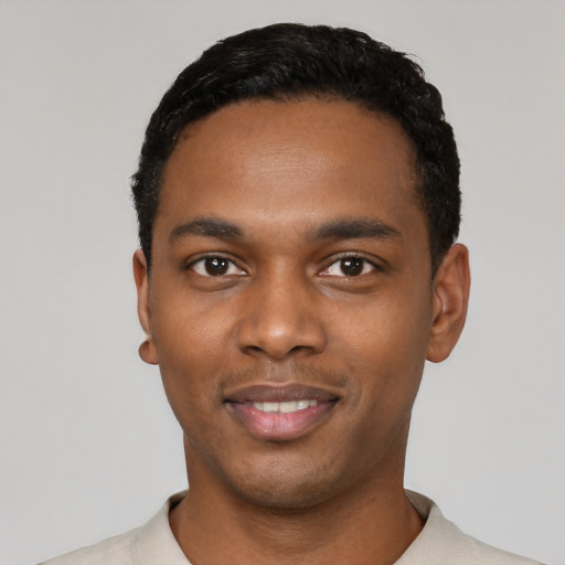 Joyful black young-adult male with short  black hair and brown eyes