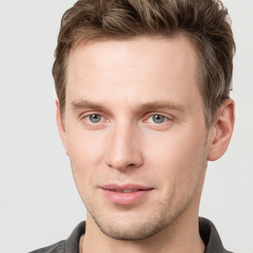 Joyful white young-adult male with short  brown hair and grey eyes