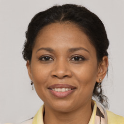 Joyful black adult female with medium  brown hair and brown eyes