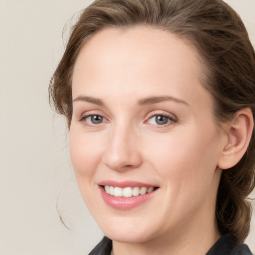 Joyful white young-adult female with medium  brown hair and blue eyes