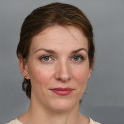 Joyful white adult female with medium  brown hair and grey eyes