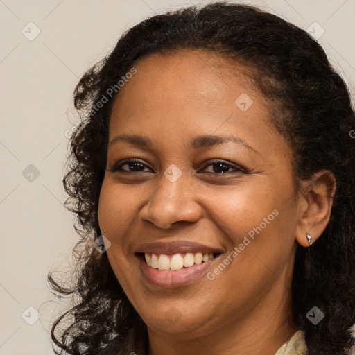 Joyful black young-adult female with long  brown hair and brown eyes