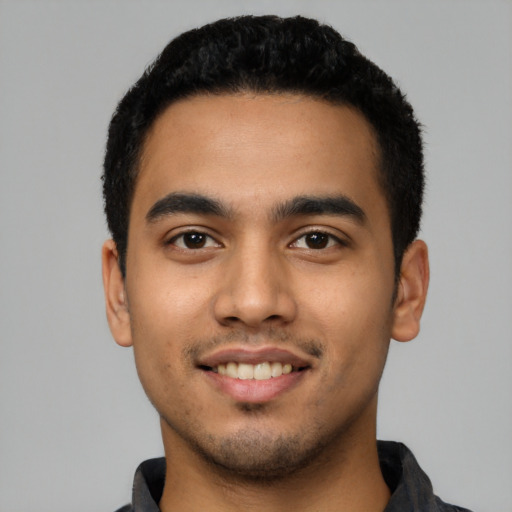 Joyful latino young-adult male with short  black hair and brown eyes